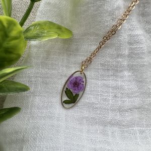 Gold Oval Necklace With A Purple Flower and Leaves